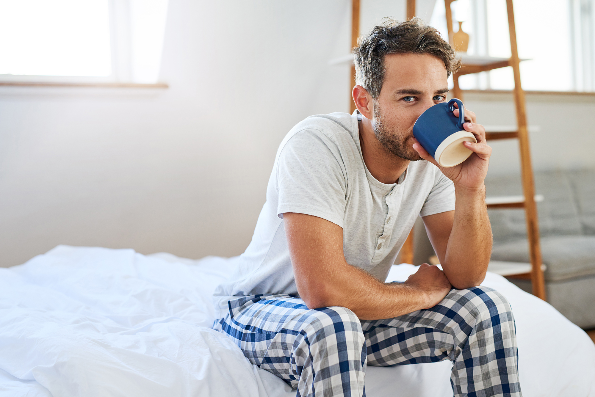 man having coffee in bed