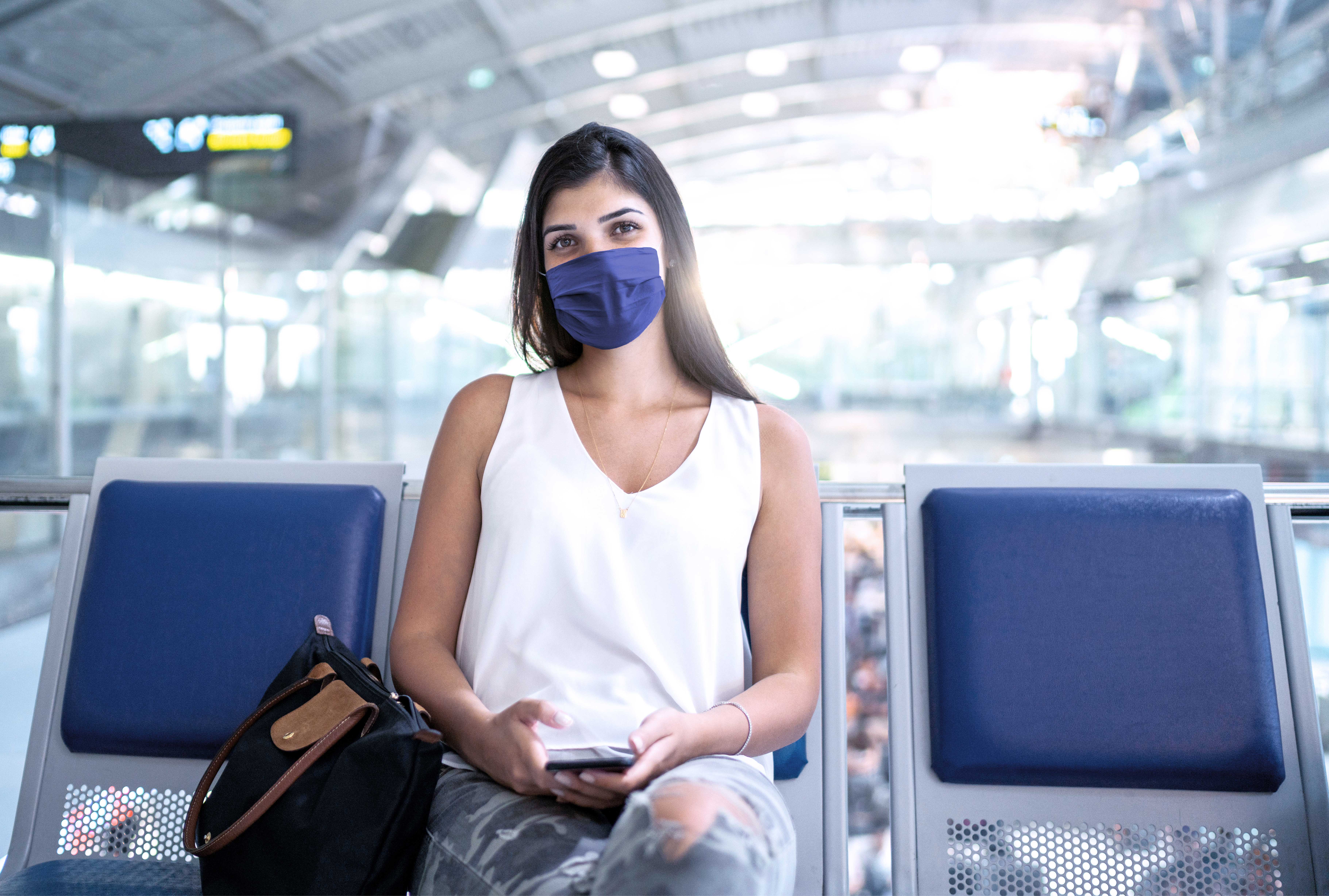 Frau am Flughafen auf Kunstleder Sitzbank